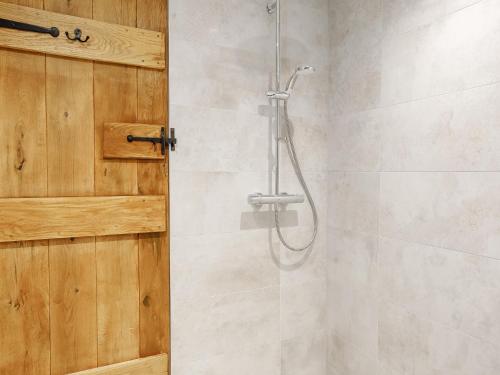 a bathroom with a shower with a wooden door at 4 Bed in Dunstable 93632 in Totternhoe