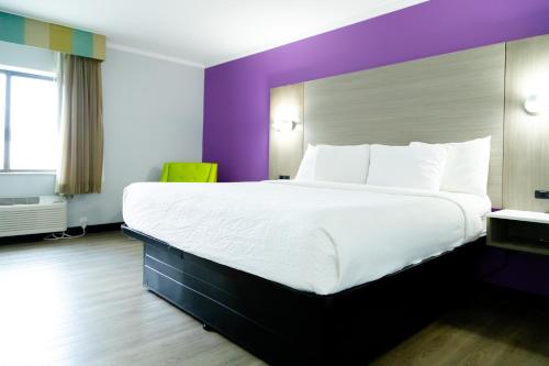 a large bed in a hotel room with purple walls at La Quinta Inn Birmingham - Inverness in Birmingham
