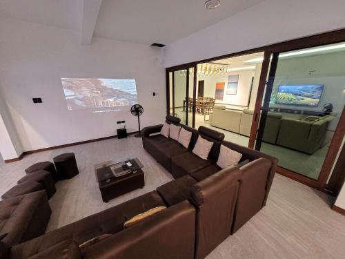 a living room with brown couches and a screen at Jay's Villa 2 (Friendship) in Angeles
