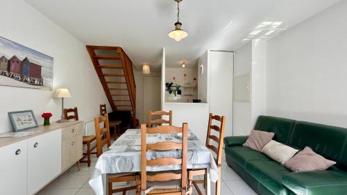 - un salon avec une table et un canapé vert dans l'établissement Maison 5 personnes à Le Crotoy avec parking, au Crotoy