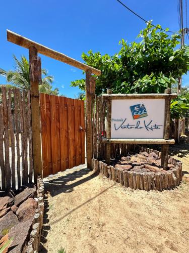 a sign in front of a wooden fence at Pousada Vento do Kite in Barra Grande