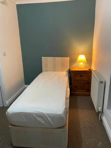 a small bedroom with a bed and a lamp on a night stand at The Granary Bar & Grill in Long Sutton