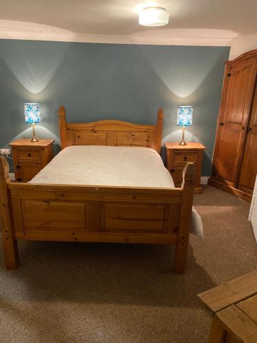 a bedroom with a bed and two night stands with lamps at The Granary Bar & Grill in Long Sutton