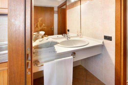 uma casa de banho com um lavatório e um espelho em Chalet Primula 11 em Santa Caterina di Valfurva