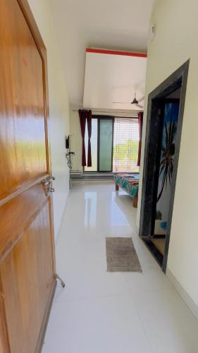 a living room with a door and a white floor at Shreyas Guest house - Tatkare Villa in Kashid