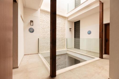 a glass pivot door in a hallway with a brick wall at Casa Señorial del Siglo XVIII in Seville