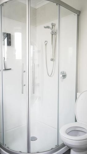 a bathroom with a glass shower with a toilet at Hamilton Hospital Retreat - 2 Bedroom Townhouse Modern Warm Quiet in Hamilton