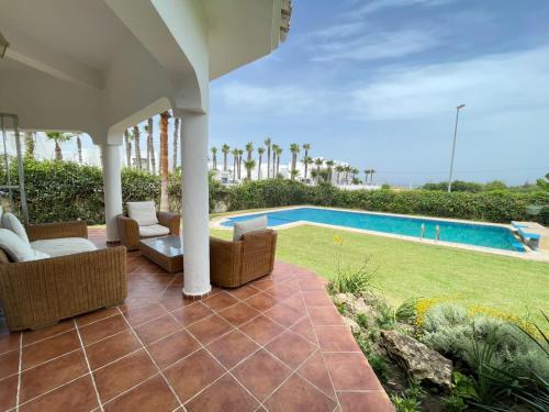 un patio con sillas y una piscina en Villa Marina Smir avec piscine, en Tetuán