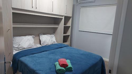 ein Bett mit grünen und roten Socken drauf in der Unterkunft Apartamento bom descanso in Serra Negra