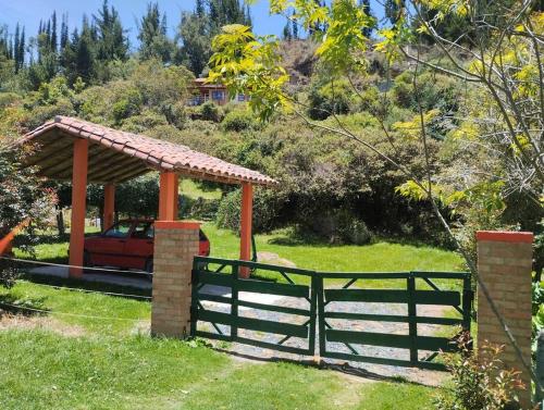a wooden gate with a pavilion in a yard at Cabaña los cerezos in Ubaté
