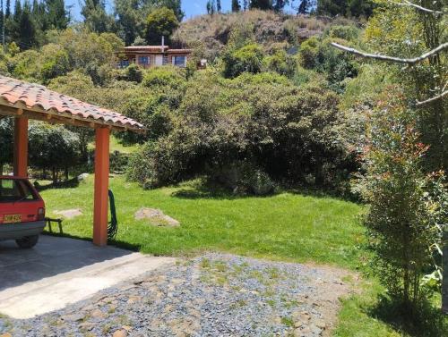 a garden with a car parked under a gazebo at Cabaña los cerezos in Ubaté