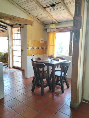 a kitchen with a table and chairs in a room at Cabaña los cerezos in Ubaté