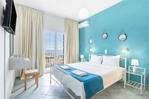 a bedroom with a bed and a blue wall at Spyridoula Studio 3 in Paleokastritsa