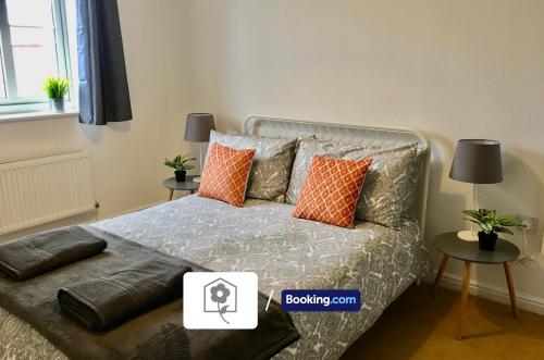 1 dormitorio con 1 cama con almohadas de color naranja y gris en Eastleigh House By Your Stay Solutions Short Lets & Serviced Accommodation Southampton With Free Wi-Fi & Close to Airport en Southampton