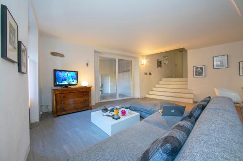 a living room with a couch and a tv at Antico Municipio - Happy Rentals in Ponte Tresa