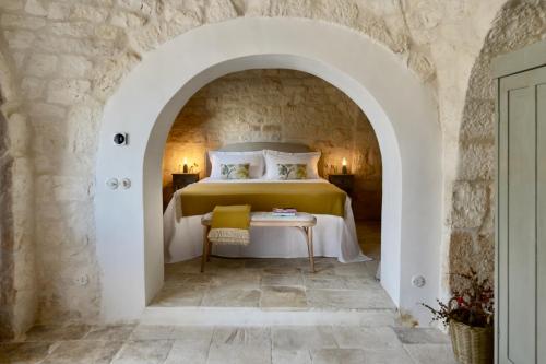 a bedroom with a bed in a stone wall at Masseria Celeste in Fasano