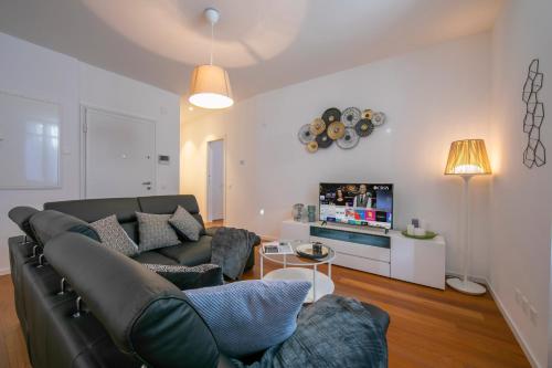 a living room with a couch and a tv at Star of Lugano - Happy Rentals in Lugano