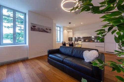 a living room with a black leather couch and a kitchen at Love of Lugano - Happy Rentals in Lugano