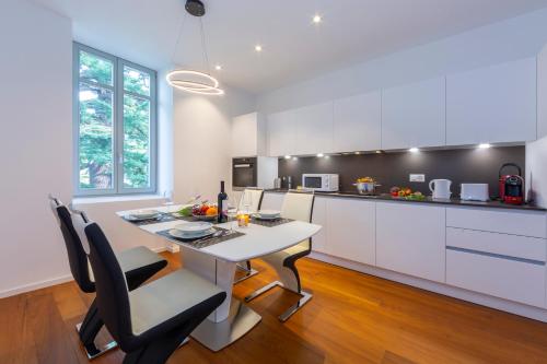 a kitchen with a white table and black chairs at Love of Lugano - Happy Rentals in Lugano