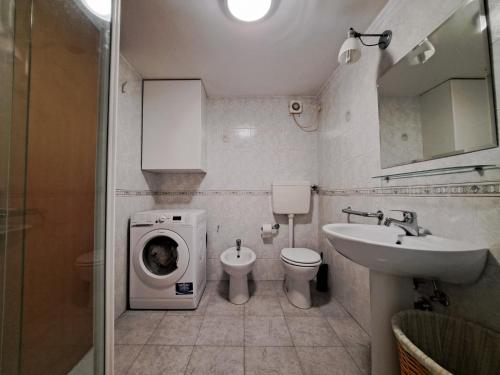 a bathroom with a washing machine and a sink at Casa Vacanze S.Tomaso in Riva del Garda