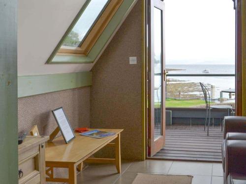 a room with a desk and a view of the ocean at Dundonald Landing Lochside Studio in Oban
