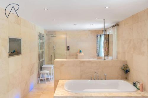 a large bathroom with a tub and a shower at Luxury Ascot Home With Indoor Heated Pool & Cinema in Ascot