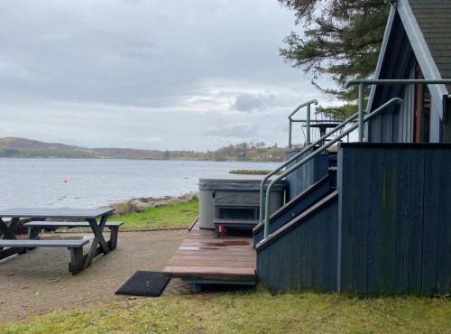 a boat sitting on a dock next to a house at Dundonald Landing Lochside Studio in Oban