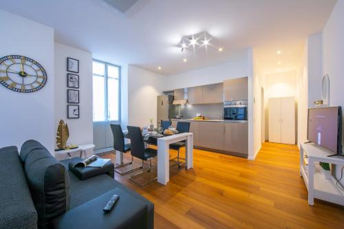 ein Wohnzimmer mit einem Sofa und einem Tisch sowie eine Küche in der Unterkunft Little Lugano in Lugano