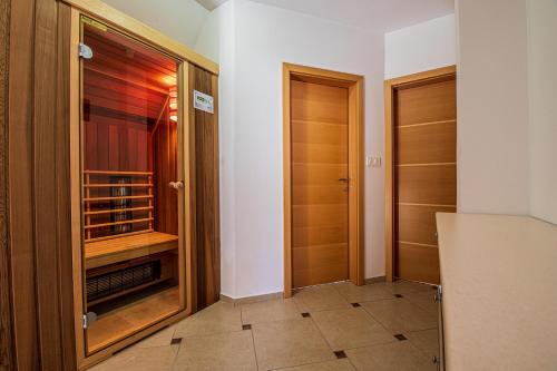 einen begehbaren Kleiderschrank mit Holztüren in einem Zimmer in der Unterkunft Sunny Weekend Sauna House - Happy Rentals in Preserje