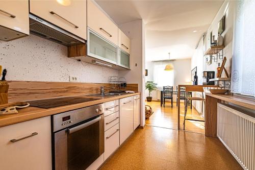 eine Küche mit weißen Schränken und Holzböden in der Unterkunft Sunny Weekend Sauna House - Happy Rentals in Preserje