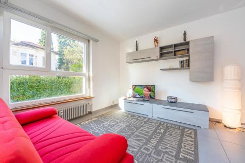 un soggiorno con divano rosso e TV di City Apartment a Lugano