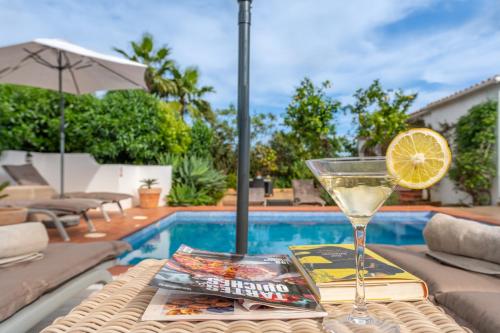 a drink on a table next to a swimming pool at Quinta das Piteiras-Turismo Rural in Silves