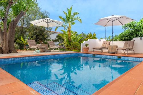 - une piscine avec des chaises longues et des parasols dans l'établissement Quinta das Piteiras Turismo Rural, à Silves