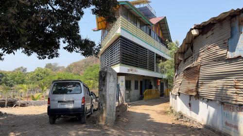 a small car parked in front of a building at Shreyas Guest house - Tatkare Villa in Kashid