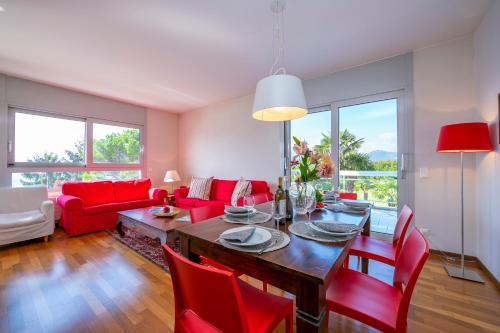 ein Wohnzimmer mit einem Tisch und roten Stühlen in der Unterkunft La Maison du Bonheur - Happy Rentals in Aldesago
