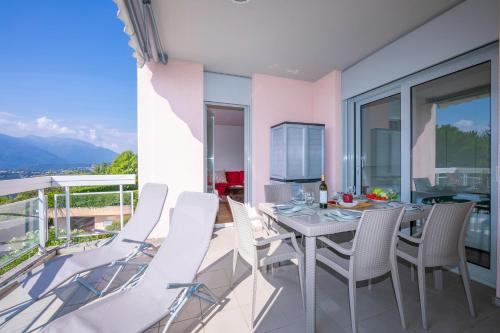 a dining room with a table and chairs on a balcony at La Maison du Bonheur - Happy Rentals in Aldesago