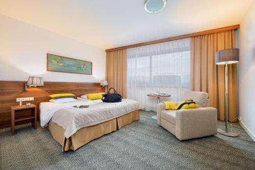 a hotel room with a bed and a chair at Arche Hotel Puławska Residence Warszawa in Warsaw