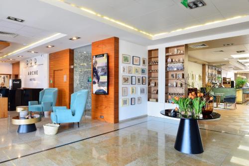 a waiting room with blue chairs and a table at Arche Hotel Puławska Residence in Warsaw