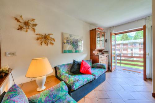 a living room with a couch and a lamp at Bramé La Fam 32 few steps from skiing - Happy Rentals in Bardonecchia