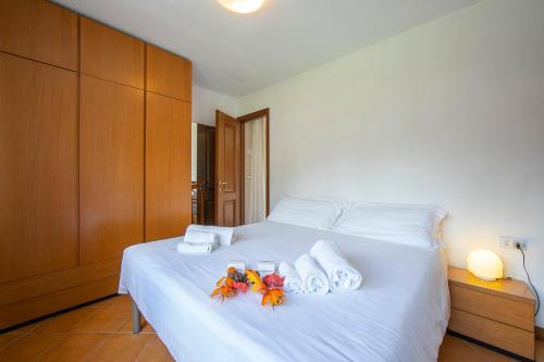 a white bed with two flip flops and towels on it at Bramé La Fam 32 few steps from skiing - Happy Rentals in Bardonecchia