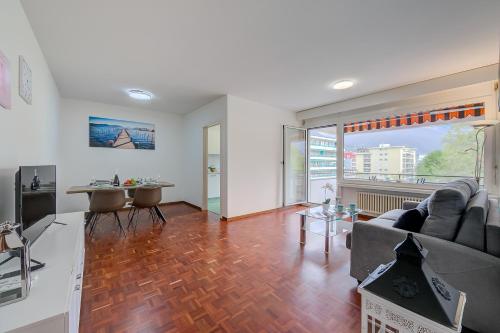 a living room with a couch and a table at Lido Apartment - Happy Rentals in Locarno