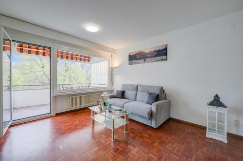 ein Wohnzimmer mit einem Sofa und einem Tisch in der Unterkunft Lido Apartment in Locarno