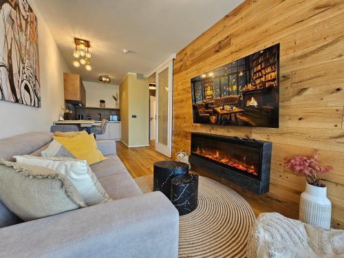 a living room with a couch and a fireplace at Design apartmán Janské Lázně 1 - by AlkaTravel, Ski&Bike in Janske Lazne