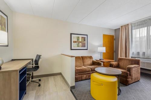 a living room with a desk and chairs and a table at Comfort Inn Herndon-Reston in Herndon