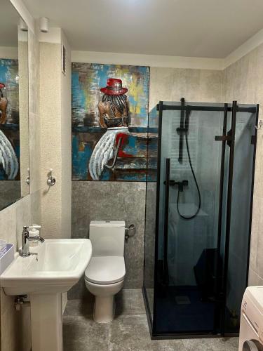 a bathroom with a shower and a toilet and a sink at Latarnia Morska in Jantar
