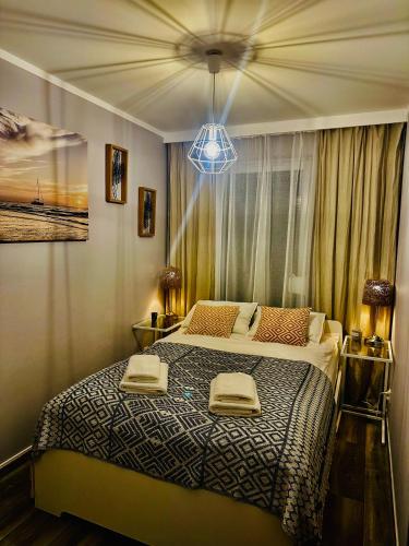 a bedroom with a bed with two towels on it at Latarnia Morska in Jantar
