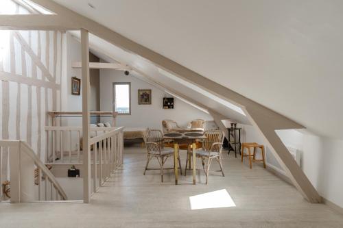 a dining room with a table and chairs in a loft at Studio et appartements Sainte Catherine in Honfleur