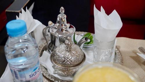 a table with a silver tea kettle and a bottle of water at Hotel apartment america in Dakhla