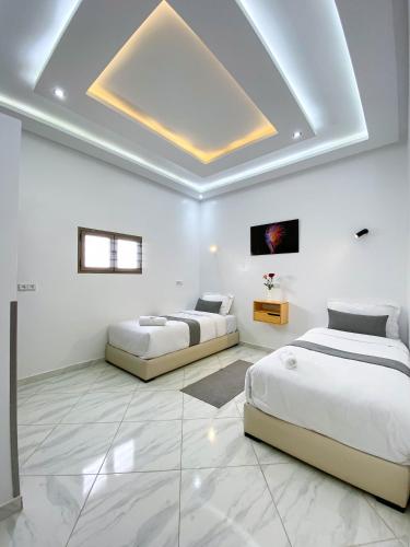 two beds in a room with white walls at Hotel apartment america in Dakhla