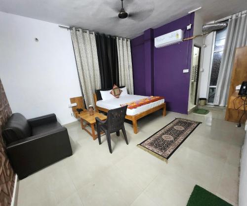 a room with a bed and a table and a couch at The kashi palace inn ,Varanasi ! fully-Air-Conditioned hotel at prime location with Parking availability, near Kashi Vishwanath Temple, and Ganga ghat in Varanasi